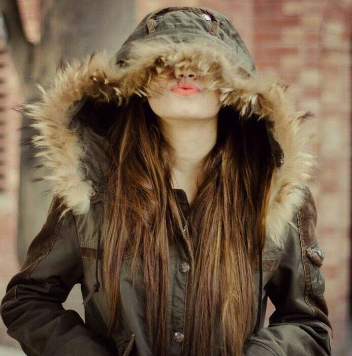 A female strolled down the street, her face hidden by using a massive coat collar.